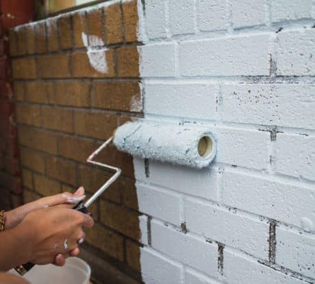 Painting on a fresh coat on brick wall